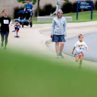 Kristen Evans' daughter running determinedly, leading the crowd
